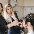 hair stylist e parrucchiera perfezionano l'acconciatura della sposa